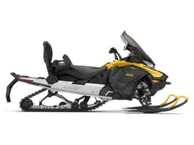 A yellow and black snowmobile with a windshield, two front skis, a rear track, and a seat for two riders, viewed from the side against a white background.